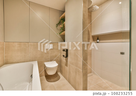 a bathroom with a toilet, sink and bathtub in the middle of the room there is a mirror on the wall 108233255