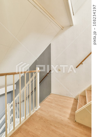 an empty room with wood flooring and white paint on the walls, there is a staircase leading up to the second floor an empty room with wood flooring and white paint on the walls, there is a staircase leading up to the second floor 108234197
