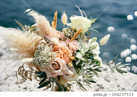 Wedding bouquet stands on a pier over the sea 108237513