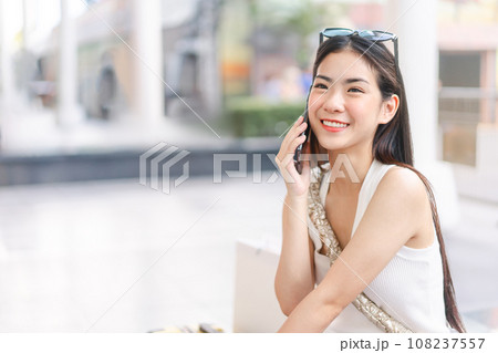 Candid portrait beautiful face asian woman with happy smile using smartphone Candid portrait beautiful face asian woman with happy smile using smartphone 108237557