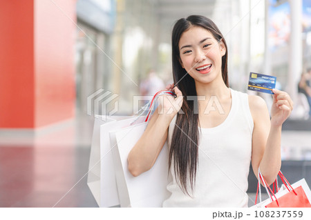 Portrait young beautiful face asian woman holding credit card and shopping bags city lifestyles 108237559