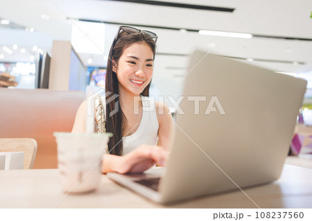 Beautiful woman freelance digital nomad job woman sitting indoors cafe with laptop Beautiful woman freelance digital nomad job woman sitting indoors cafe with laptop 108237560