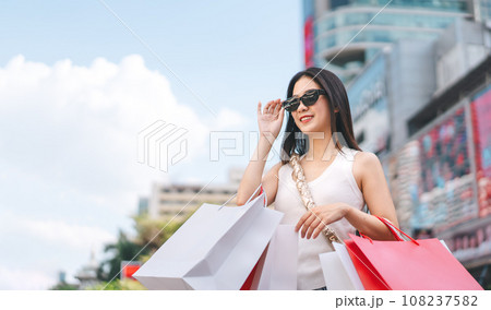 Asian woman shopping bags wear sunglasses lifestyles with buying consumerism at outdoor department store 108237582