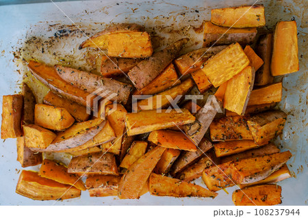 Baked sweet potato with spices lies in a glass dish Baked sweet potato with spices lies in a glass dish 108237944