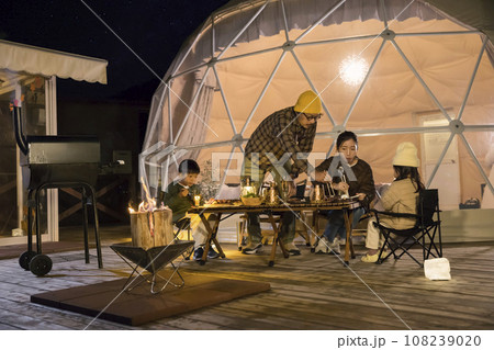 グランピング施設で夕飯を食べる家族イメージ 108239020