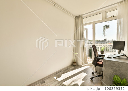 a room with a desk, chair and large window looking out onto the cityscapear com logo on the wall a room with a desk, chair and large window looking out onto the cityscapear com logo on the wall 108239352