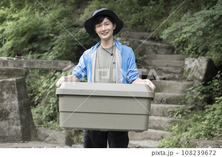 トランクカーゴを運ぶ若い男性　キャンプイメージ 108239672