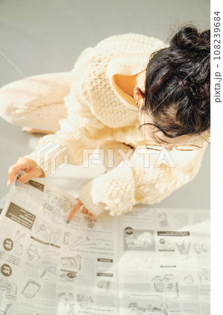 床に座って新聞を読む女性 108239684