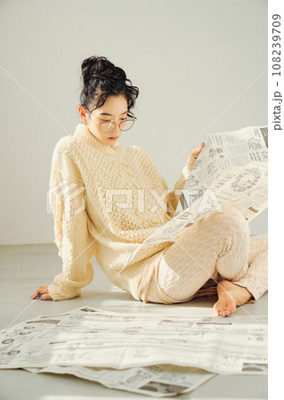 床に座って新聞を読む女性 床に座って新聞を読む女性 108239709
