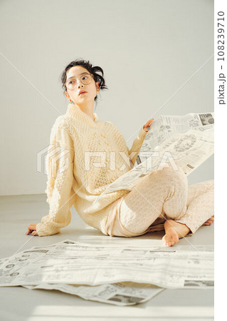床に座って新聞を読む女性 108239710