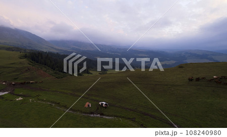 Pink-purple sunset in mountains with green fields Pink-purple sunset in mountains with green fields 108240980