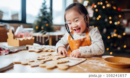 Smiling asian child with down syndrome decorates christmas cookies. Merry Christmas and Happy New Year concept. Smiling asian child with down syndrome decorates christmas cookies. Merry Christmas and Happy New Year concept. 108241657