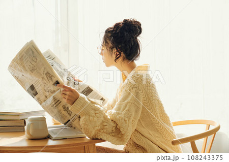 カフェで新聞を読む女性 108243375
