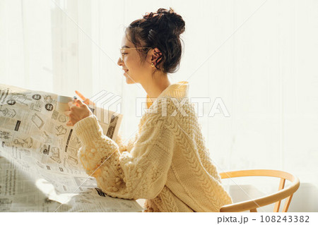 カフェで新聞を読みながら談笑する女性 108243382