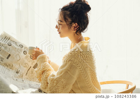 カフェで新聞を読みながら談笑する女性 108243386
