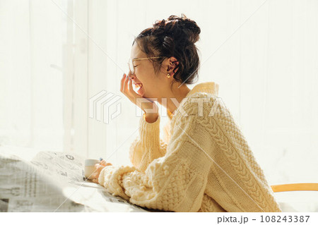 カフェで新聞を読みながら談笑する女性 108243387