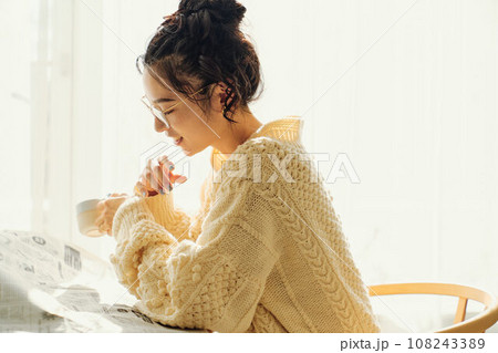 カフェで新聞を読みながら談笑する女性 108243389