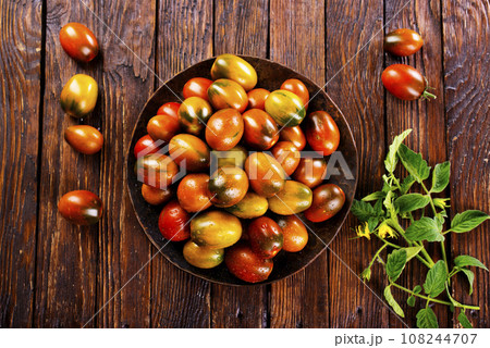 The harvest of assorted tomatoes, banner. Colorful organic tomatoes on a large dish. Tomatoes different varieties. Top view 108244707