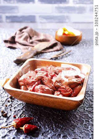 Raw liver with onion in wooden bowl Raw liver with onion in wooden bowl 108244751