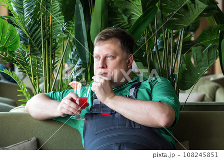 Worker drinking a cooling cocktail during lunch break while sitting on the sofa 108245851
