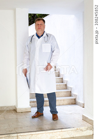 Portrait of a doctor, adult man in a medical gown, full length 108245852