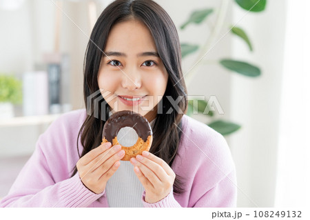 ドーナツを食べる若い女性 108249132