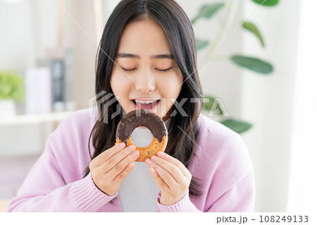 ドーナツを食べる若い女性 108249133