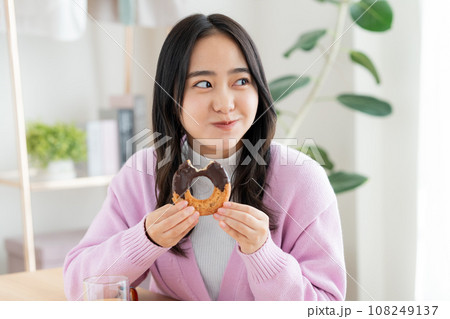 ドーナツを食べる若い女性 108249137