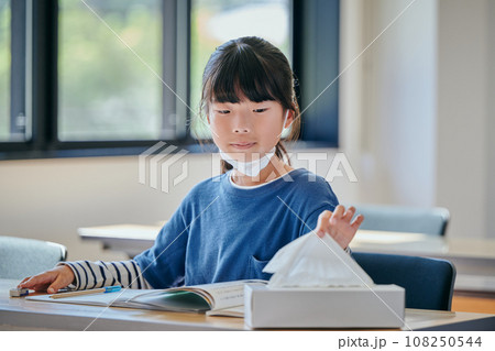 ティッシュペーパーを手に取る小学生の女の子 108250544