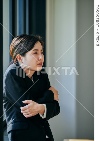 窓際で体が震える冷え性の若い女性会社員 108250561