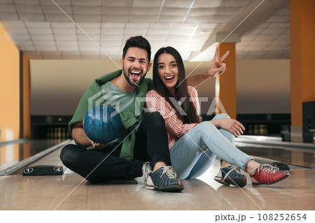 Happy young couple with ball in bowling club Happy young couple with ball in bowling club 108252654