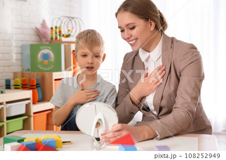 Speech therapist working with little boy in office 108252949