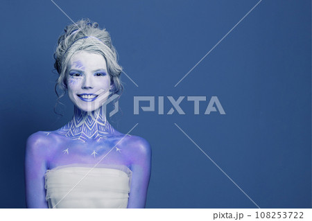 Funny winter queen woman actress with stage makeup and cute smile on blue banner background. Funny winter queen woman actress with stage makeup and cute smile on blue banner background. 108253722
