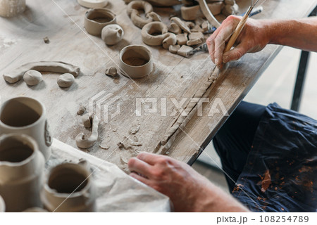 Male potter hands working with clay. Art work concept. Male potter hands working with clay. Art work concept. 108254789