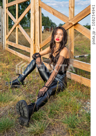 Beautiful young caucasian woman sitting at the ranch gate. Beautiful young caucasian woman sitting at the ranch gate. 108254941