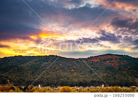 京都盆地の秋、晩秋の桂川河川敷、パステルカラーに染まった夕暮れ空と、紅葉に染まった愛宕山脈 108255000