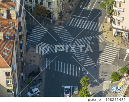 Top view over a crowd pedestrian crossing road intersection, Belgrade. Aerial view od traffic at busy scramble crosswalk 108255423