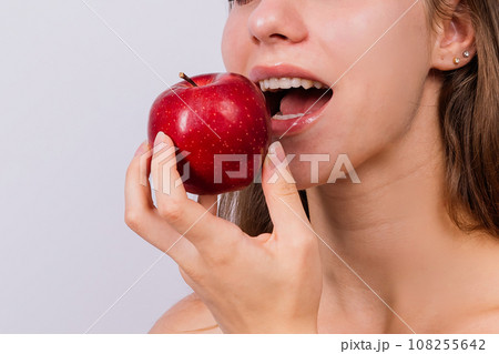 Morning breakfast. Woman with healthy teeth holding apples on grey isolated background. 108255642