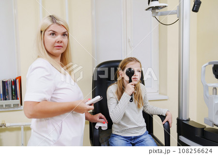 teen girl in ophthalmologist's office. teen girl in ophthalmologist's office. 108256624