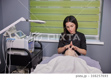 Enzyme Mask, Beauty Rejuvenation, Facial Treatment. Woman undergoes contemporary beauty treatment involving enzyme mask and facial brush peel procedure. Enzyme Mask, Beauty Rejuvenation, Facial Treatment. Woman undergoes contemporary beauty treatment involving enzyme mask and facial brush peel procedure. 108257693