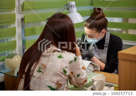 hand care, Electric machine, Manicure process. Manicure process in beauty salon, cleaning of nails with milling cutter, filing nails at table by manicurist, removing nail plate with milling machine 108257713