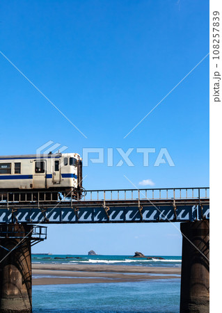 青空の下細田川の架かる鉄橋走る日南線キハ40 108257839