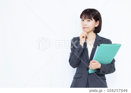 白い背景の前で悩んでいるスーツを着た30代の働く女性 108257846