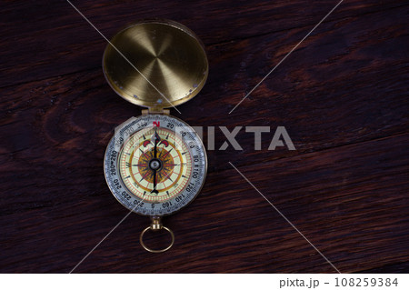 Vintage retro compass on wooden background 108259384