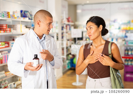 Woman complaining about heartache to pharmacist 108260090