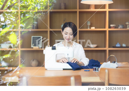 日中ミシンで裁縫する女性 108263039