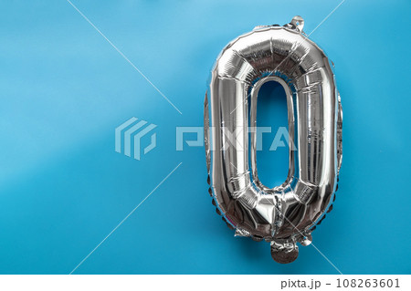 0 zero metallic balloon isolated on blue background. Greeting card silver foil balloon number Happy birthday holiday concept. Copy space for text. Celebration party congratulation 108263601