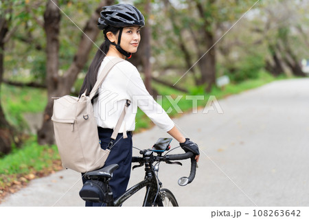 ビジネスカジュアル姿でロードバイクを押して歩く若い女性 後ろ姿 ビジネスカジュアル姿でロードバイクを押して歩く若い女性 後ろ姿 108263642