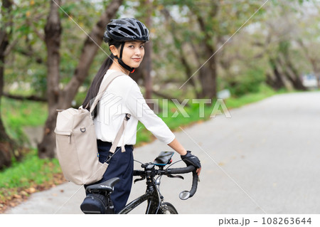 ビジネスカジュアル姿でロードバイクを押して歩く若い女性 後ろ姿 108263644