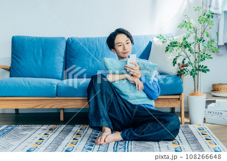 リビングでスマホを使う若い男性 108266648